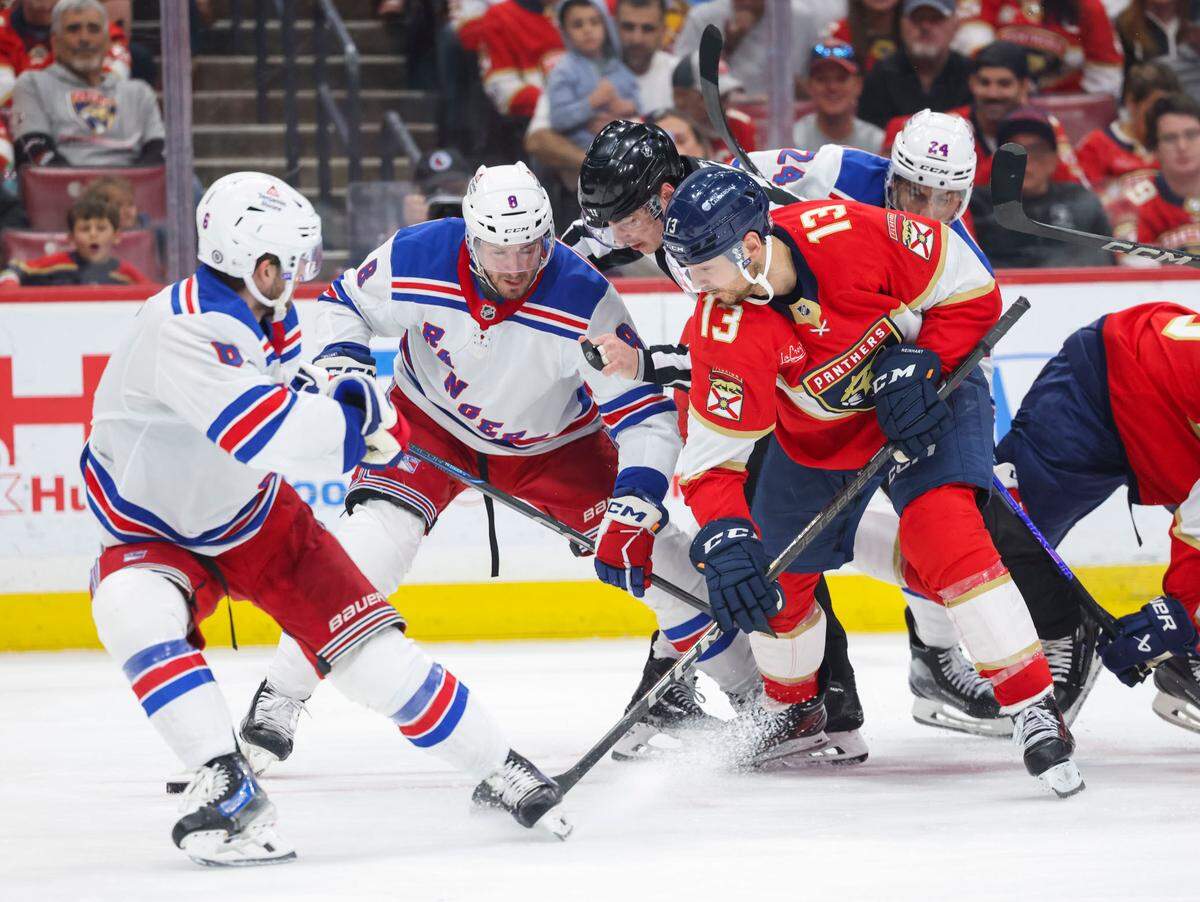 Florida Panthers center Sam Reinhart (13) and New York Rangers left wing J.T. Miller (8) watch the puck as its released during the third period of a game on Monday, April 14, 2025, at Amerant Bank Arena in Sunrise, Fla. The Panthers lost, and the Rangers won 5-3.