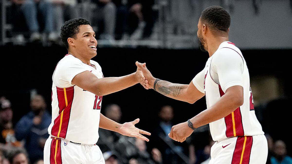 Dru Smith #12 and Norman Powell #24 of the Miami Heat slap hands during the third quarter against the Detroit Pistons at Little Caesars Arena on January 01, 2026 in Detroit.