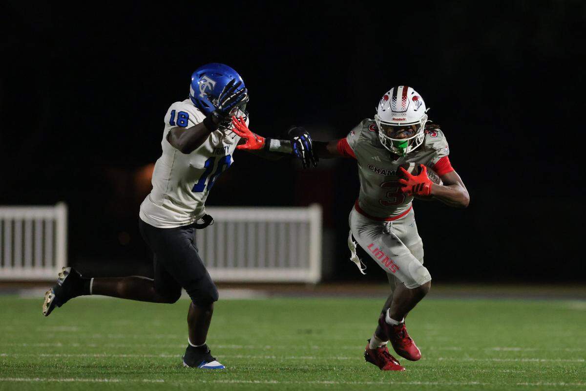 Chaminade-Madonna Lions wide receiver Tromon Isaac (3) carries the football against Trinity Christian Academy linebacker Rashon Lewis (18) during the first half of a Class 1A football state semifinal game at Chaminade-Madonna College Preparatory on Friday, Dec. 5, 2025 in Hollywood, Fla.