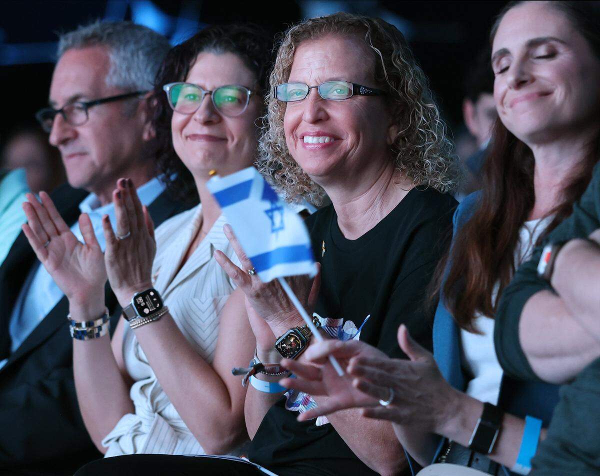 Jewish Federation of Broward County Chairman Doug Berman, left, and Audra Berg, CEO, reflect and react after Karni Guez’s remarks while sitting alongside Congresswoman Debbie Wassermann Schultz, right. The Jewish Federation of Broward County held a community-wide commemoration, marking the second anniversary of the deadly attacks in Israel on October 7, 2023.