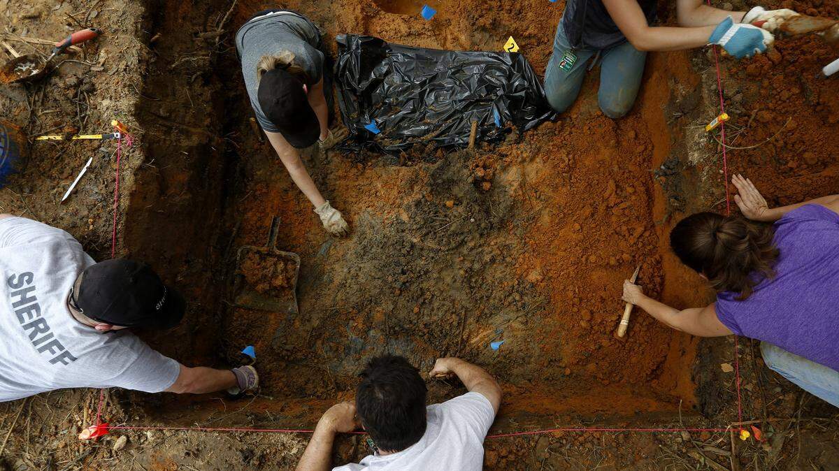 Anthropologists from the University of South Florida exhuming grave sites at the Arthur G. Dozier School for Boys in Marianna on Sept. 1, 2013, after discovering human remains buried in an unmarked grave. The area covered by the trash bag contains skull fragments. 