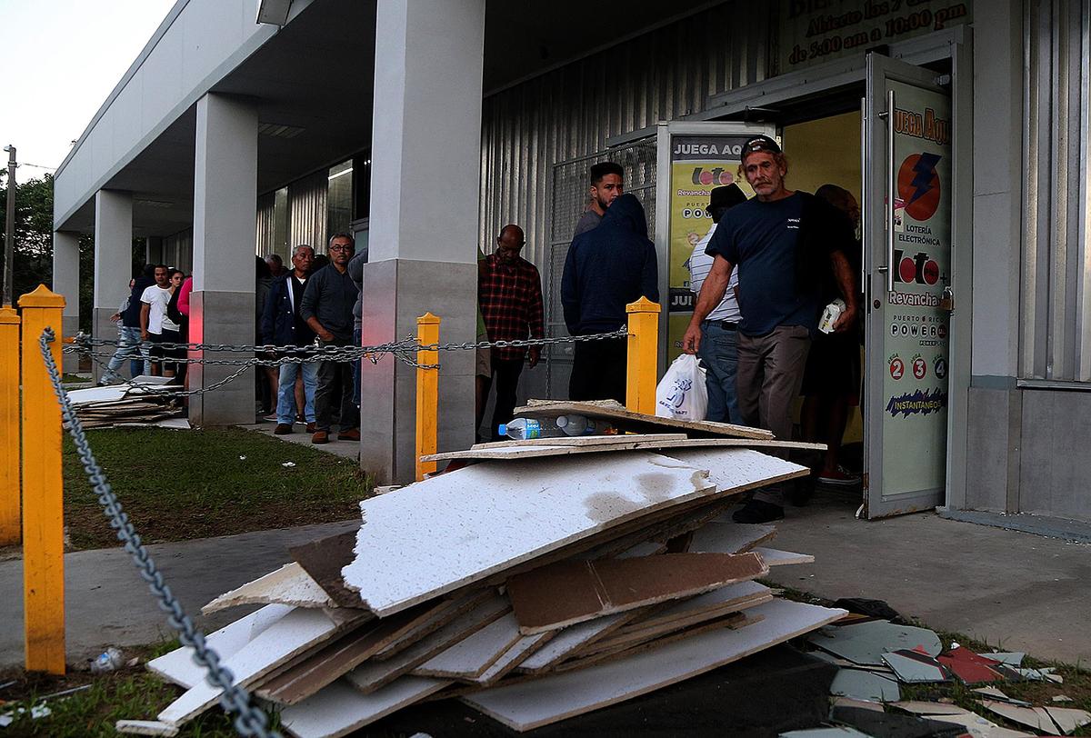 Vecinos hacen fila para comprar pan y leche en La Estrella, en el poblado de Guayanilla, en la costa sur de Puerto Rico, en una imagen del . Cientos, quizás miles, de puertorriqueños han estado durmiendo a la intemperie desde que una serie de terremotos comenzó el 28 de diciembre.