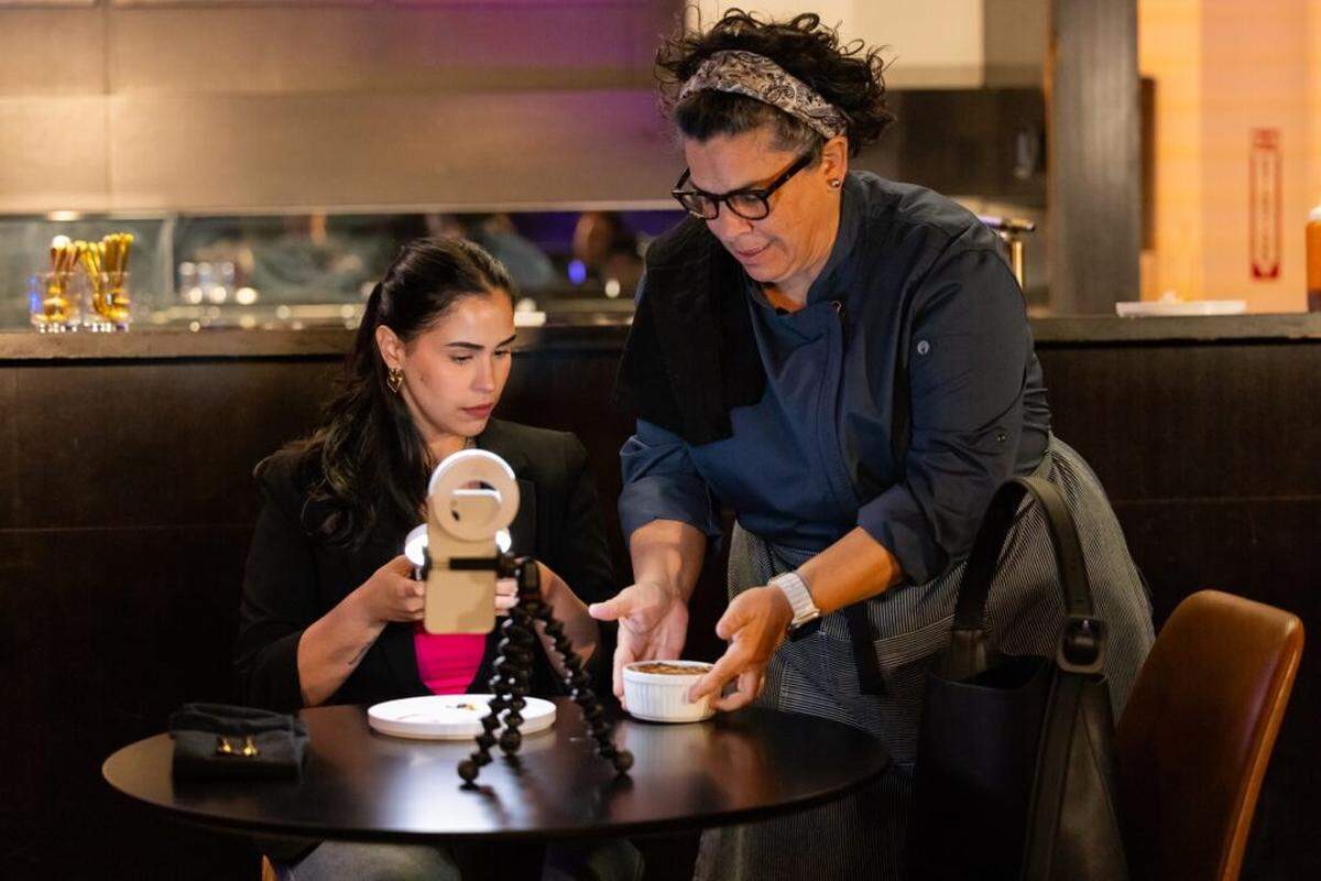 Marcela Paguaga as a savvy social media influencer and Carmen Pelaez as Chef Luna in Miami New Drama’s “Lincoln Road Hustle.”