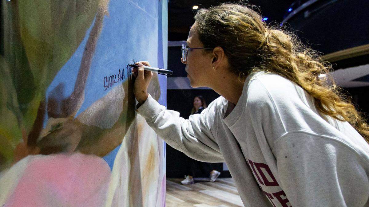 In January, Sarah Painter signs a mural before Vice President Kamala Harris speaks in Tallahassee, Florida, in honor of the 50th anniversary of Roe v. Wade.