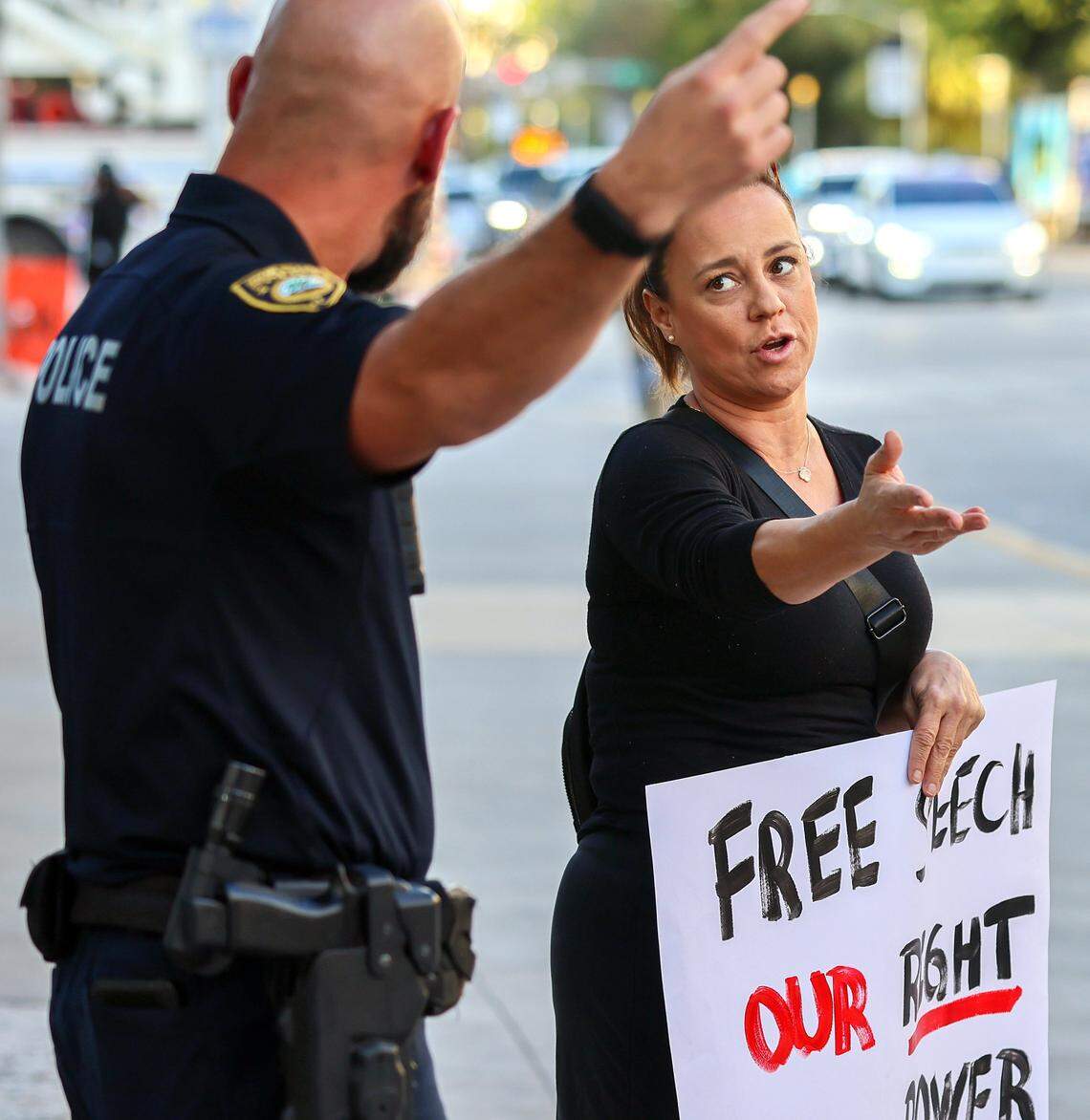 Miami Beach Police Lt. Han, left, requests resident Raquel Pacheco, right, to move her demonstration away from the 17th and Washington Ave intersection as Pacheco request a logical reason on Wednesday, February 4, 2026, near the New World Center, where Mayor Steven Reiner delivered his State of the City address in Miami Beach, Florida.