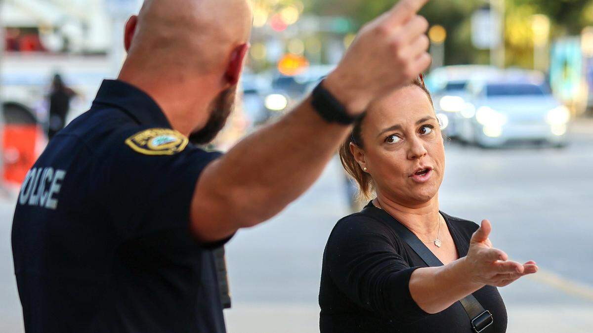 Miami Beach Police Lt. Han, left, requests resident Raquel Pacheco, right, to move her demonstration away from the 17th and Washington Ave intersection as Pacheco request a logical reason on Wednesday, February 4, 2026, near the New World Center, where Mayor Steven Reiner delivered his State of the City address in Miami Beach, Florida.