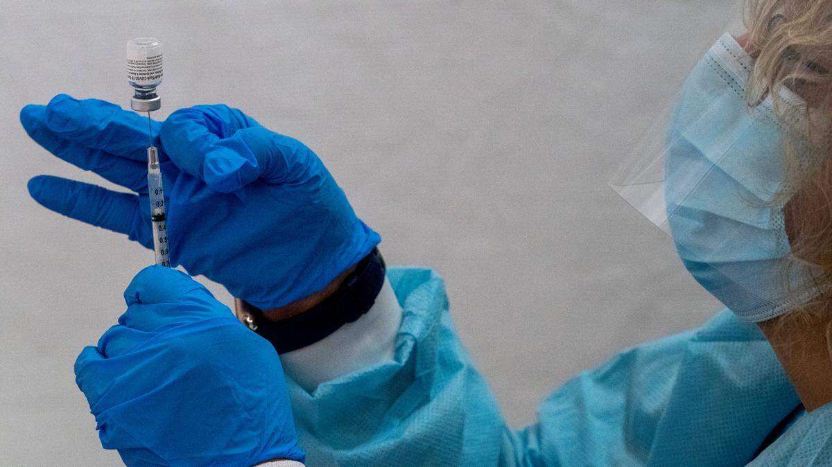 A pharmacist fills a syringe with the Pfizer-BioNTech coronavirus vaccine at a pop-up site in the Bronx borough of New York in January 2021. An FDA committee recommended an update to COVID-19 booster shots to target omicron and its subvariants.