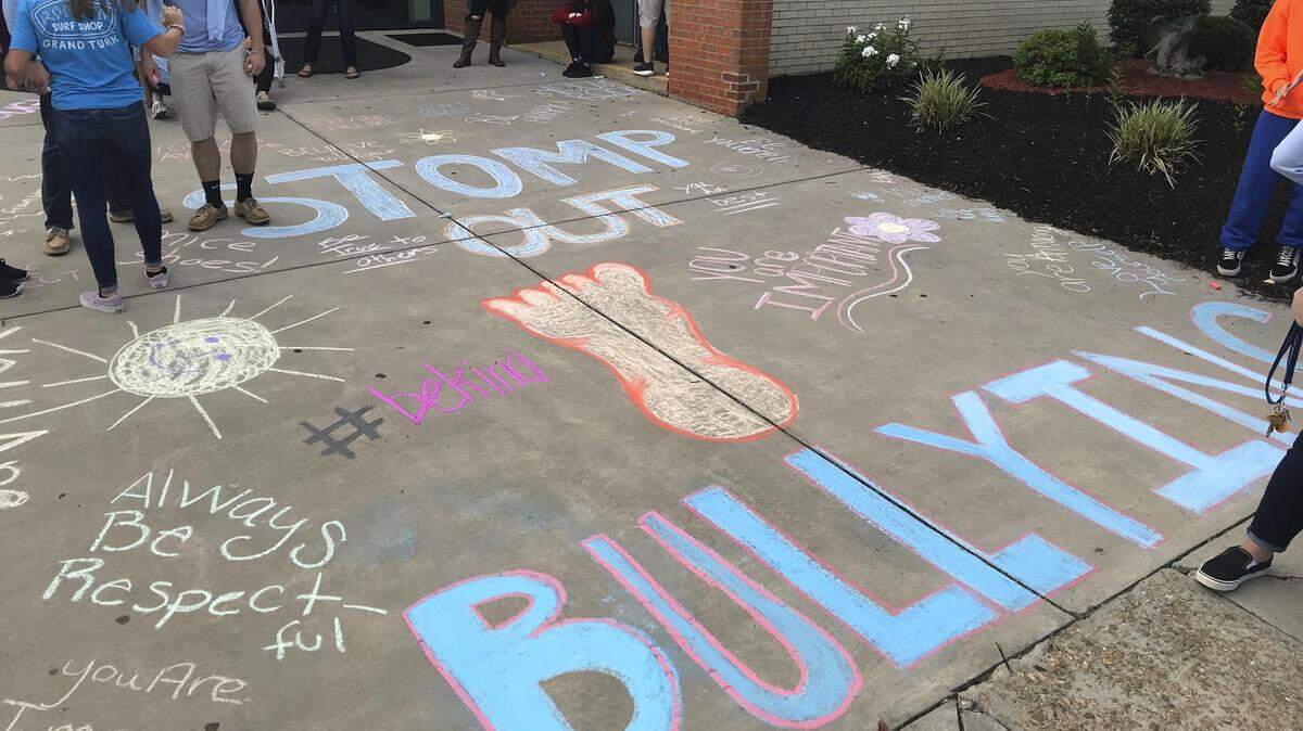 Chatham, Va., High School is marking National Bullying Prevention Month, and activities on Oct. 7, 2019, included students handing out candy and greeting other students at the start of the day. Students also held anti-bullying signs from the windows of a parked bus and used chalk to write anti-bullying messages on the sidewalk in front of the school’s entrance.