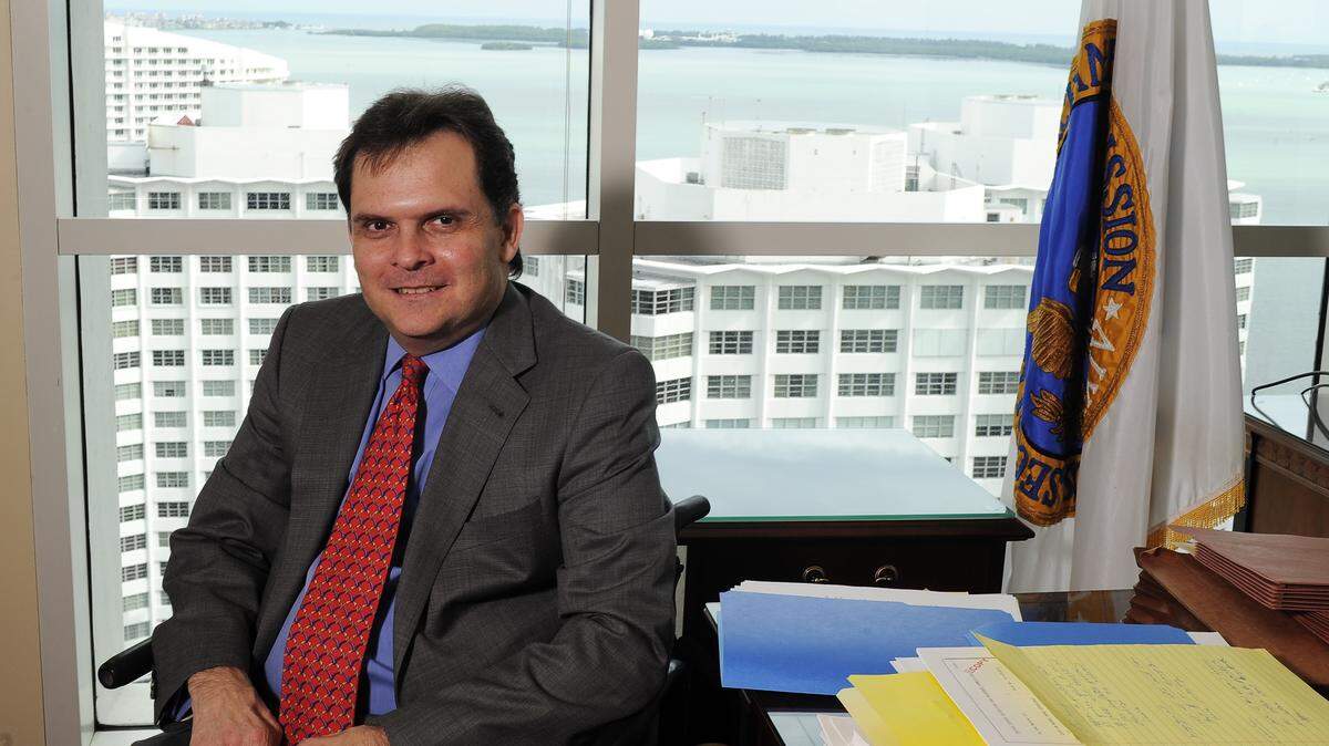 Lawyer Eric Bustillo recently retired as the director of the Securities and Exchange Commission’s Miami regional office. He is pictured in his office overlooking Biscayne Bay after he was hired for the position.
