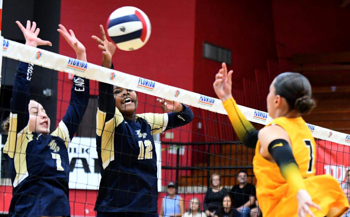 North Broward senior Layni Tobias (12) and eighth-grader Emma Luehrs (7) block a Merritt Island shot during the Class 4A girls volleyball state championship game on Saturday at Polk State College in Winter Haven.