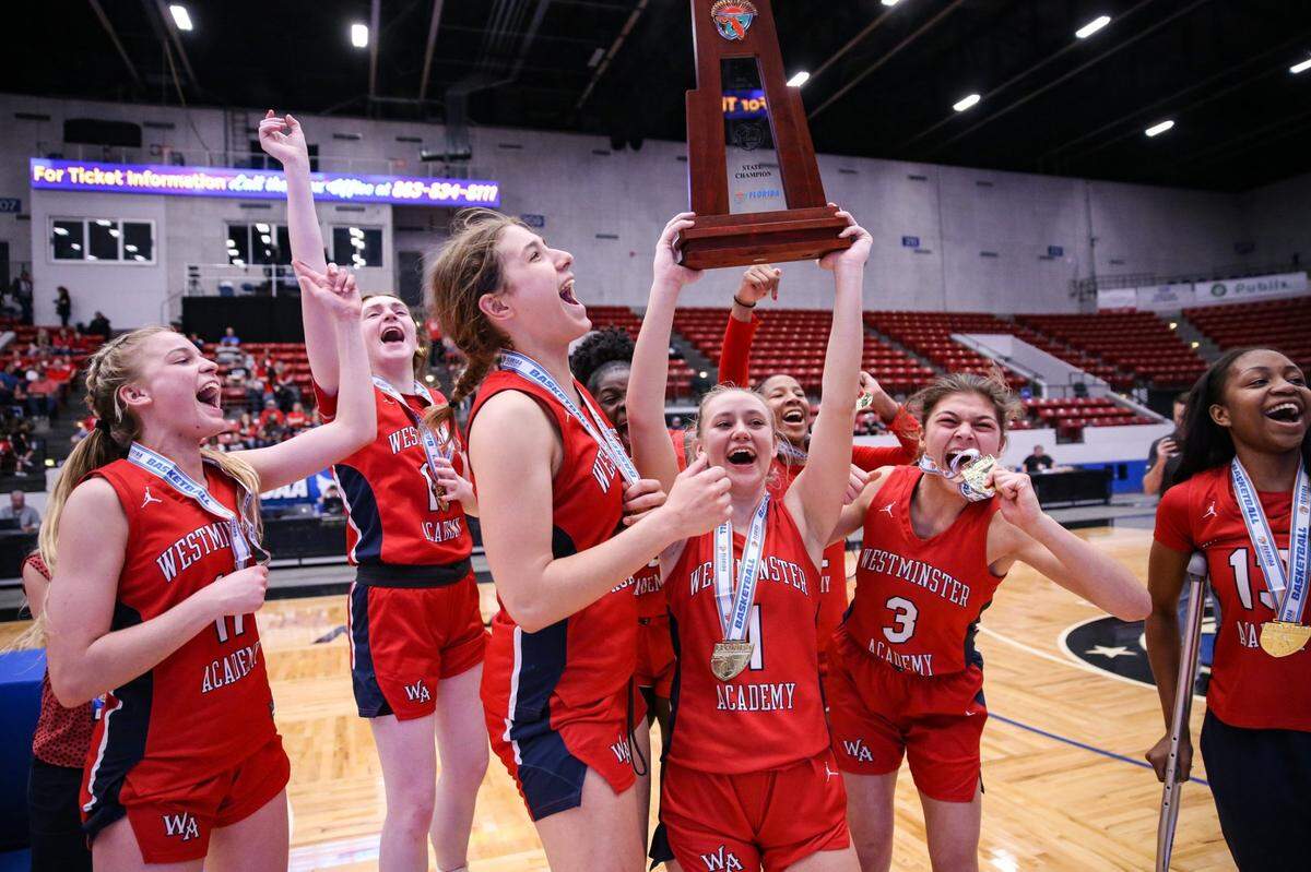 Westminster Academys Claire Erickson (1) hoists the state championship trophy after defeating Cardinal Mooney in a Class 3A girls basketball state championship at the RP Funding Center in Lakeland on Friday, February 25, 2022.