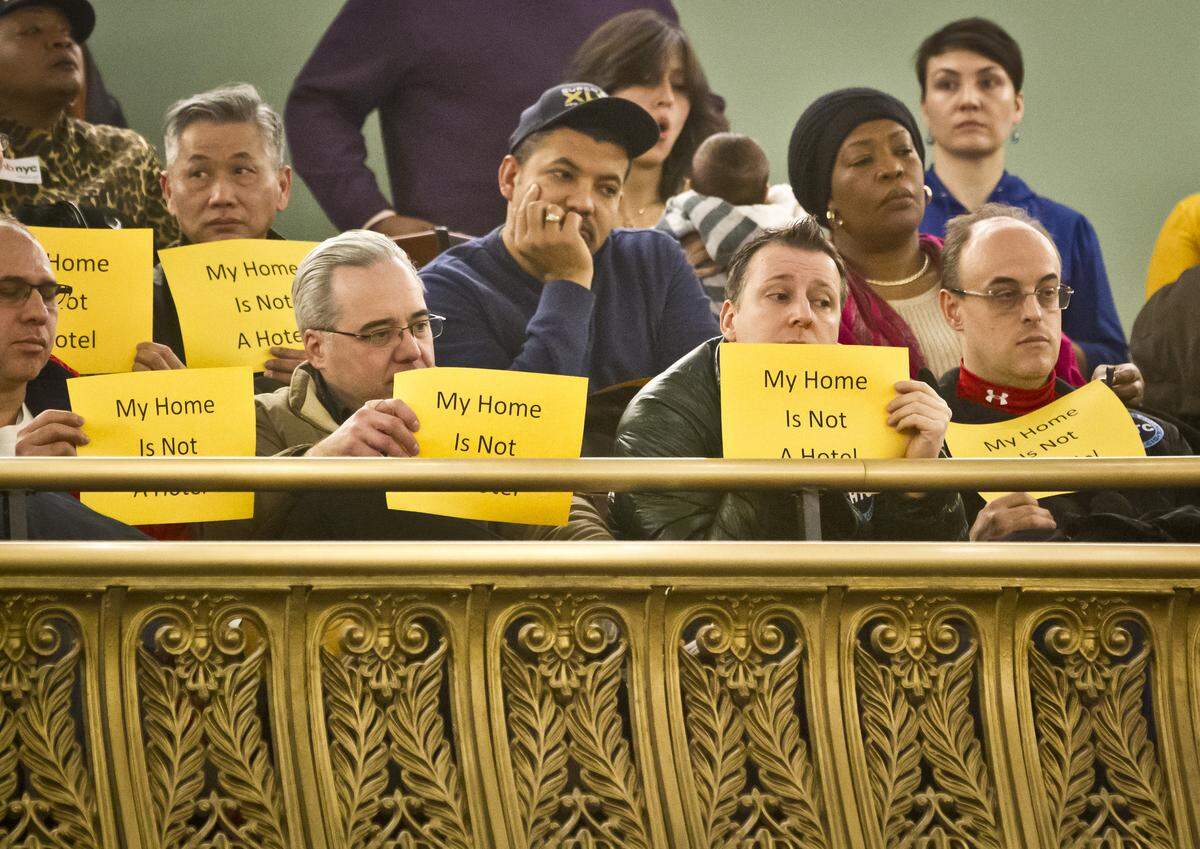 Opponents of Airbnb hold signs that reads "My home is not a hotel," during a hearing at City Hall, in January 2015 in New York. New York City's comptroller’s office this month released a report saying Airbnb has raised rents and gentrified neighborhoods in Manhattan and Brooklyn.