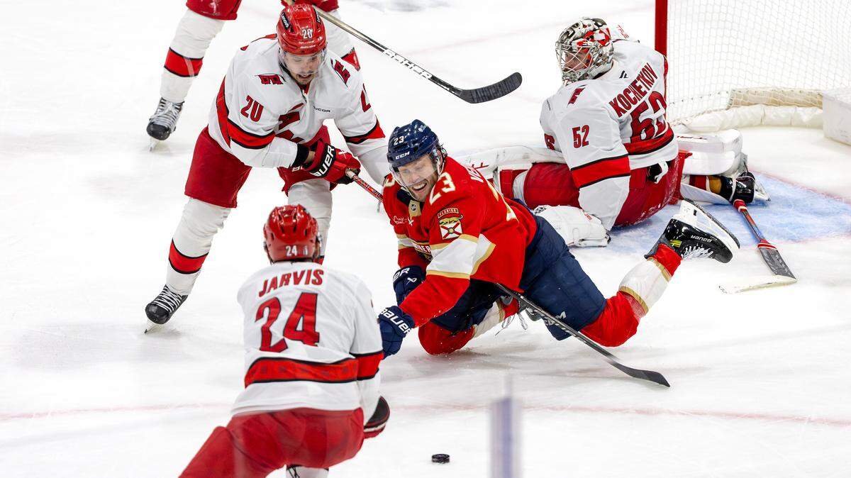 Florida Panthers center Carter Verhaeghe (23) battles for a loose puck with Carolina Hurricanes center Sebastian Aho (20) and center Sebastian Aho (20) during the second period of Game 3 in the Eastern Conference Final of the NHL Stanley Cup Playoffs at Amerant Bank Arena on Saturday, May 24, 2025, in Sunrise, Fla.