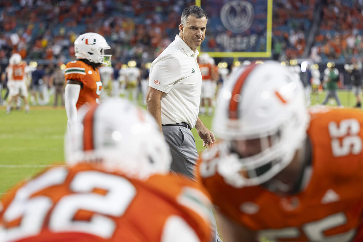 Miami Hurricanes head coach Mario Cristobal watches his players run drills before playing against the Notre Dame Fighting Irish in their NCAA football game at Hard Rock Stadium on Sunday, Aug. 31, 2025, in Miami Gardens, Fla.
