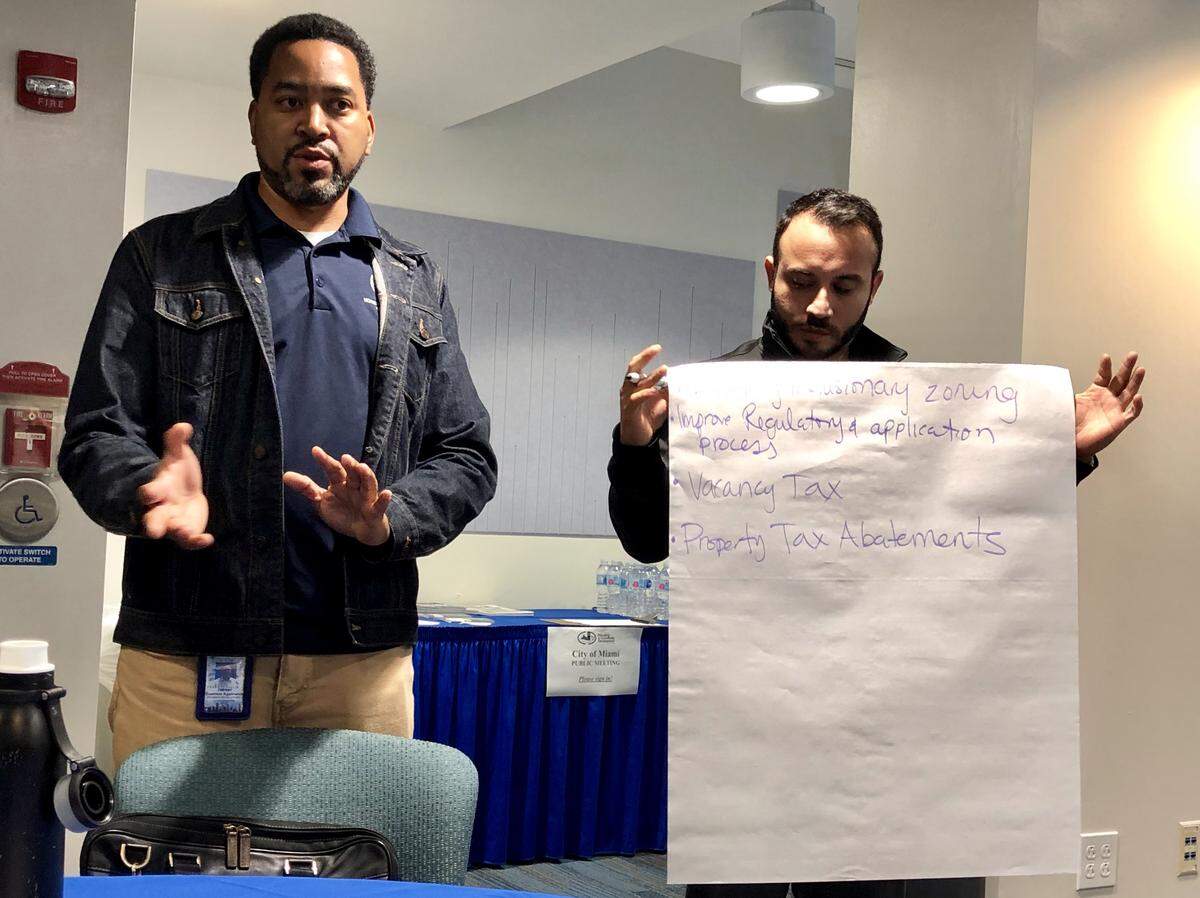 Hernan Guerrero, left, leads a discussion at a recent community meeting on how to expand affordable housing in Miami. A housing development coordinator for the city of Miami, Guerrero guided conversations about strategies for creating more affordable units among community members such as Michael Roman, right.