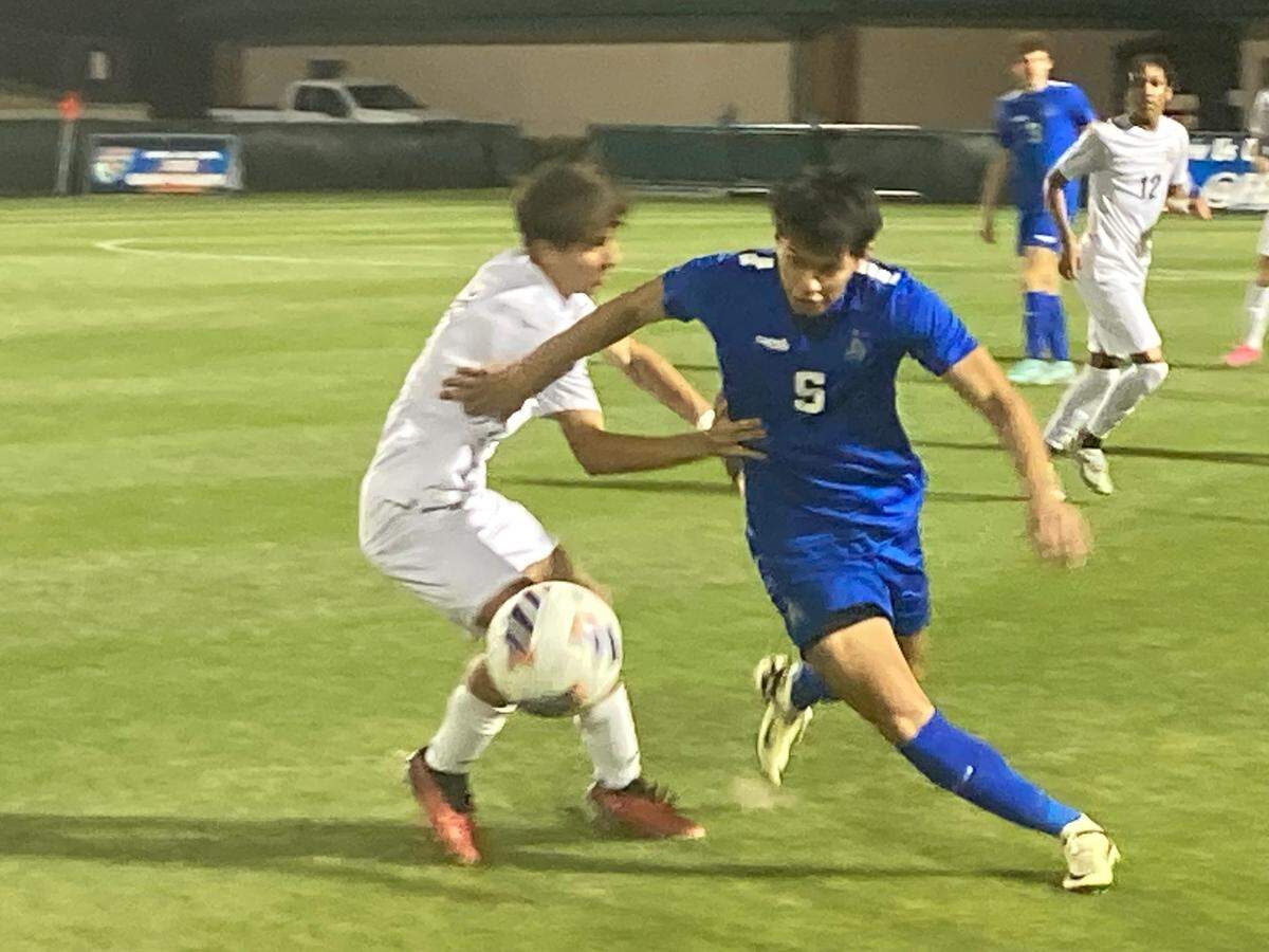 Pembroke Pines Charter’s Matias Orellana (left) battles Panama City Beach Arnold’s Landon Ullman for the ball during Tuesday night’s Class 5A state boys soccer semifinal at Spec Martin Stadium in DeLand, Fla.