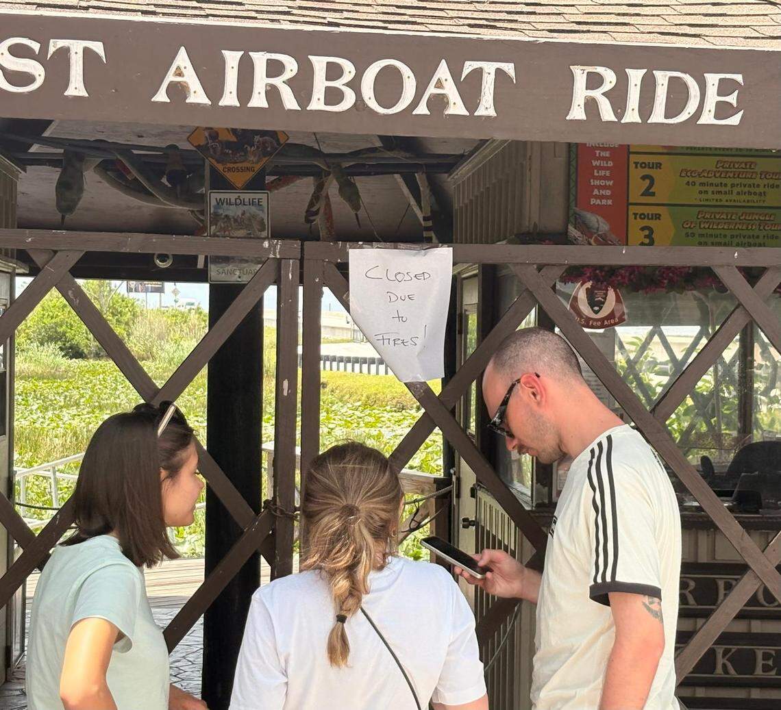 Georgia Feorenza, Martina Cennello and Luca Daniel discuss their plans at Everglades Safari Park on Tamiami Trail in west Miami-Dade County after seeing a sign that airboat rides had been canceled due to a wildfire on Tuesday, April 28, 2026.