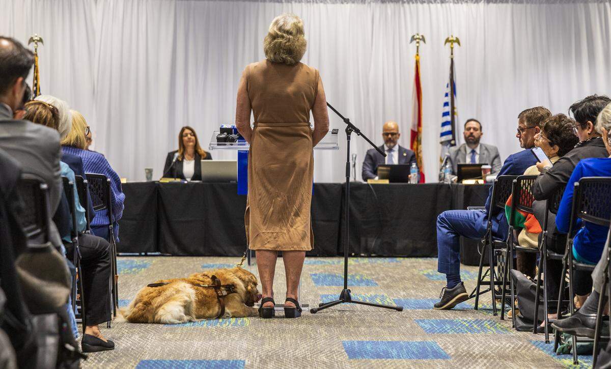Dr. Janice Barletson with her service dog Dusty, speaks during a special board meeting, held by the Miami Dade College Board of Trustees to discuss the potential real estate transactions including the authorization to convey a +/-2.63 acre surface parking lot at the Wolfson Campus for further conveyance for a Presidential Library for Donald J. Trump, celebrated at the MDC Hialeah Campus, on Wednesday, December 02 , 2025.