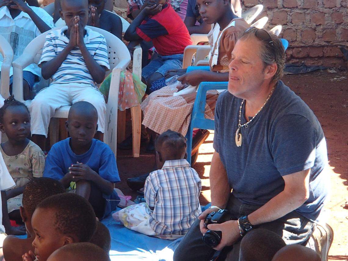 Mike Forster is seen here with several children in a village in Uganda, where he went on several annual missions to help poor children. The Monroe County Commissioner died of COVID in September.