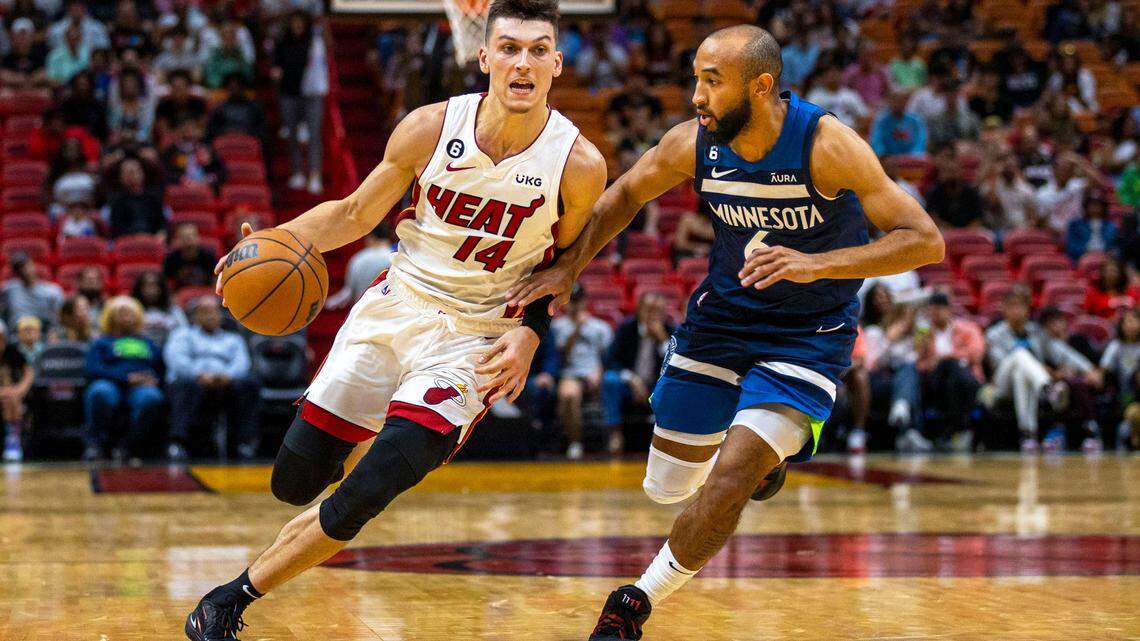 Miami Heat guard Tyler Herro (14) dribbles around Minnesota Timberwolves guard Jordan McLaughlin (6) during the first half of an NBA preseason basketball game at FTX Arena in Miami, Florida, on Tuesday, October 4, 2022.