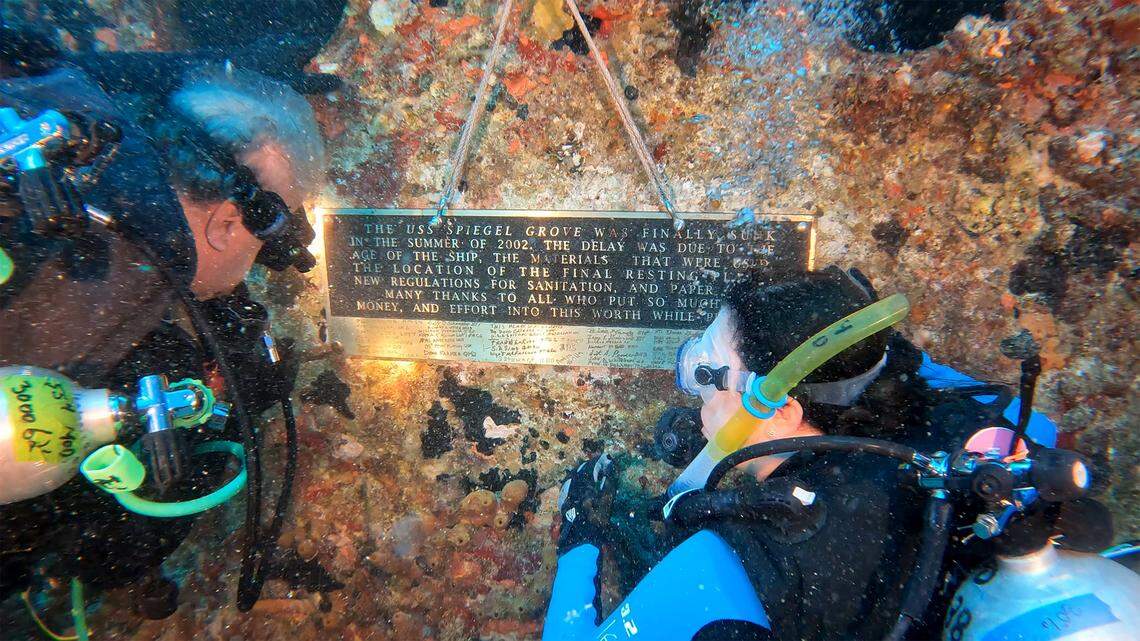 Karen Berrios watches Jon Hazelbaker install a commemorative plaque on the Spiegel GroveSunday, May 15, 2022. The ship is a decommissioned 510-foot-long Naval Landing Ship Dock that was sunk in 2002 to become an artificial reef in the Florida Keys National Marine Sanctuary off Key Largo.