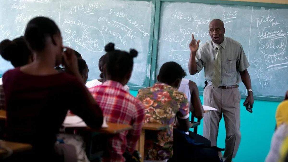 In 2019, students listen to school Director Jean Marc Charles at the Lycée school in Petion-Ville, Haiti.