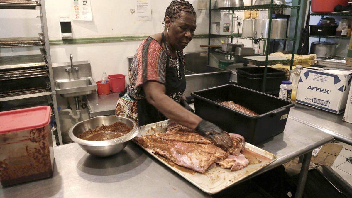 Miami, June 7, 2019 - Analie Michel rubs seasoning on racks of ribs before cooking at Bon Gout Barbecue as she and the rest of the crew prepare to open for business. Bon Gout Barbecue, 99 NW 54th St, Little Haiti