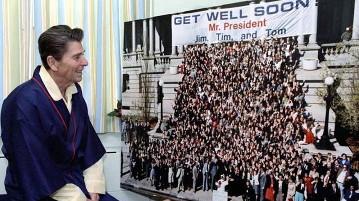 President Reagan looks at a “Get Well” photograph while recovering at George Washington Hospital in April 1981.