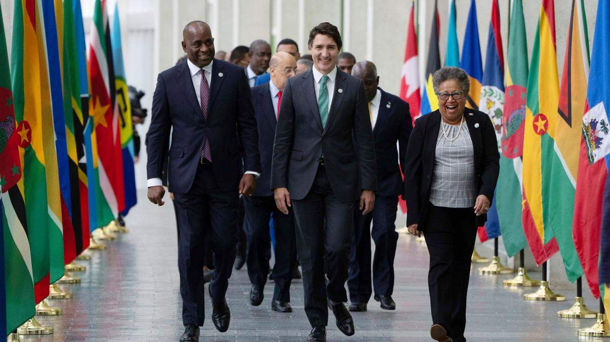 Canada Prime Minister Justin Trudeau laughs with CARICOM Secretary General Carla Natalie Barnett and the Prime Minister of Dominica Roosevelt Skerrit as leaders walk to a family photo and the first session at the Canada CARICOM Summit, Wednesday, Oct. 18, 2023 in Ottawa, Canada. (Adrian Wyld/The Canadian Press via AP)