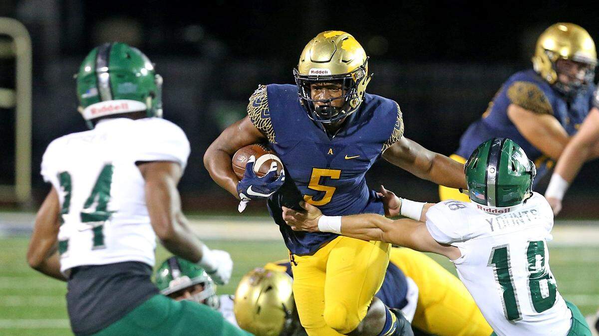 St Thomas Aquinas’ Daniel Carter (5) stiff arms Venice’s Cristian George in the first quarter Friday, Nov., 30, 2018, at St Thomas Aquinas  in Fort Lauderdale.