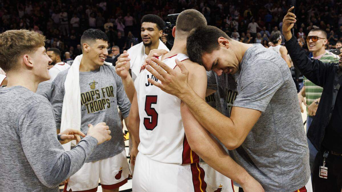 Miami Heat center Vlad Goldin (50) hugs forward Nikola Jovic (5) after winning a game in overtime against the Cleveland Cavaliers on Nov. 10, 2025, at Kaseya Center in Miami.