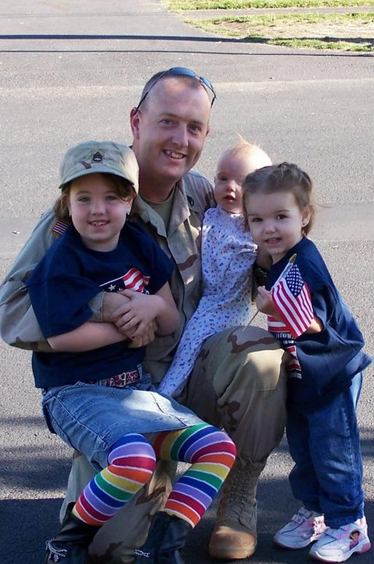 Jimmy Novak embraces his three children, Owen, Samantha and Karaha, after coming back from his first combat deployment in 2005.