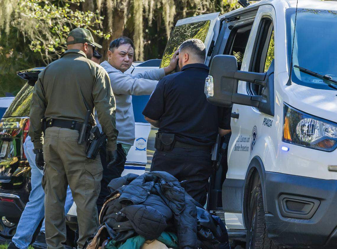Multiple law enforcement officers processed a group of illegal migrants and two suspected smugglers arrested at 11600 Old Cutler Road in Coral Gables early morning, on Tuesday, Jan. 28, 2025. Portal won second place for spot news photography in the 2026 FSNE journalism awards.