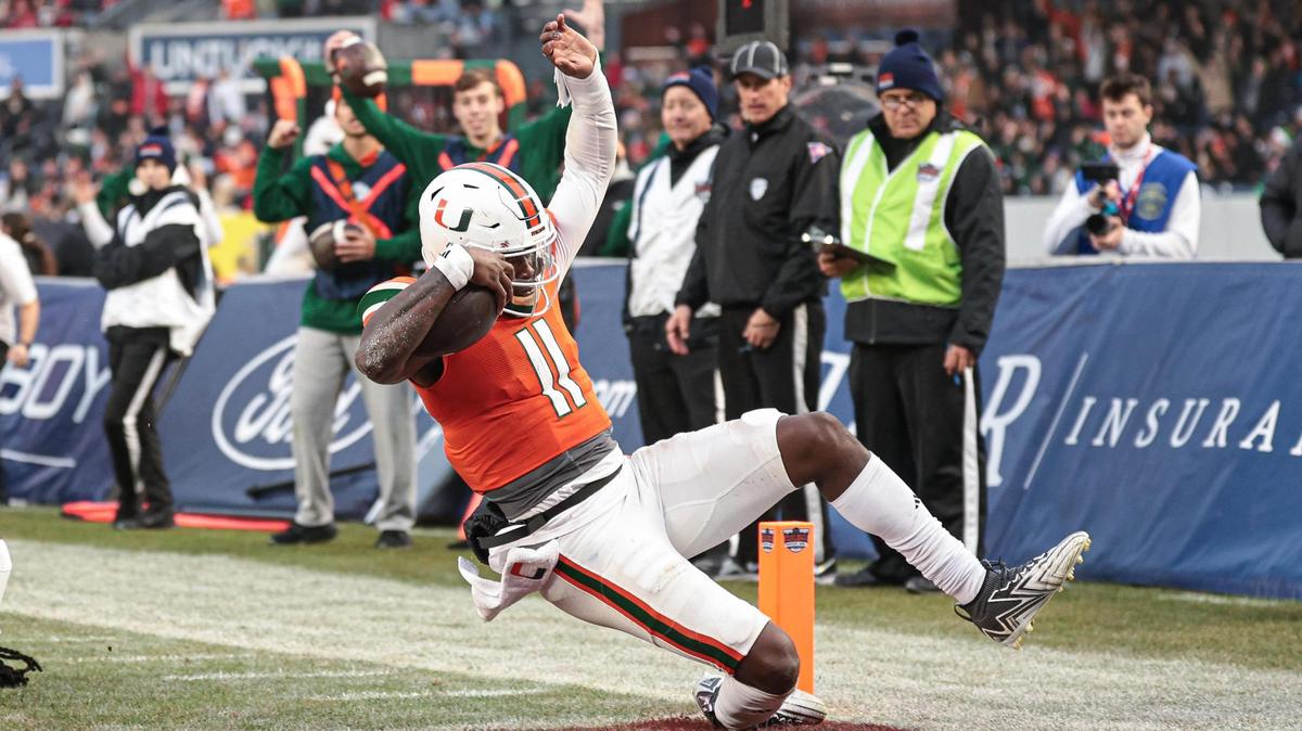 Dec 28, 2023; Bronx, NY, USA; Miami Hurricanes quarterback Jacurri Brown (11) scores a touchdown in front of defensive back Flip Dixon (10) during the first half of the 2023 Pinstripe Bowl at Yankee Stadium. Mandatory Credit: Vincent Carchietta-USA TODAY Sports