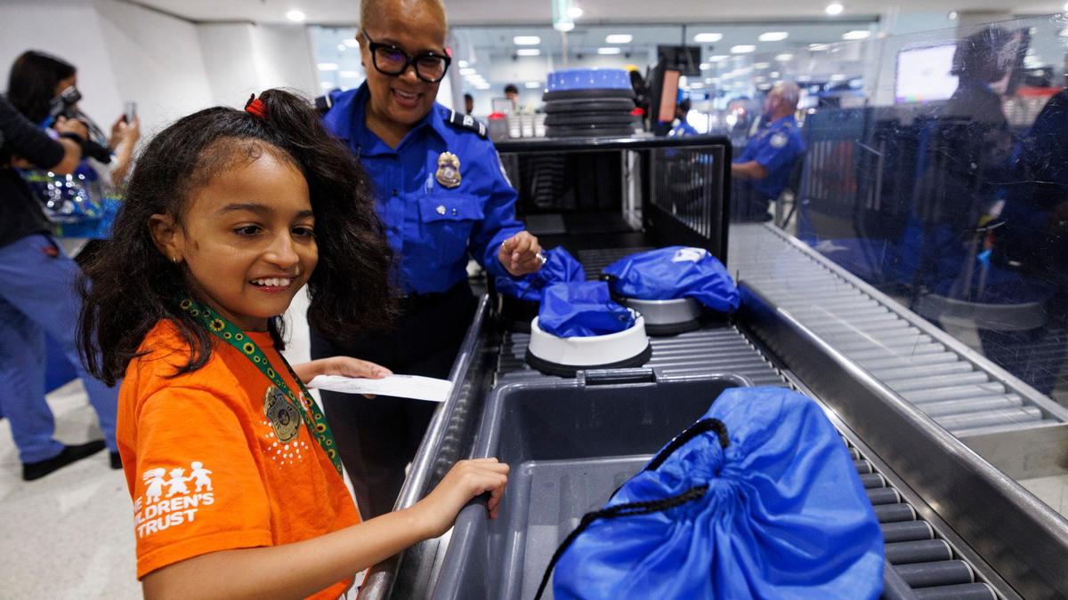 Victoria Castellano, 10, left, goes through TSA with the help of agent Sandra Touya during an airport readiness drill with Easterseals South Florida kids to prepare them for experiencing air travel on Tuesday, July 23, 2024, at Miami International Airport. Many of the kids have autism or other disabilities that can make airports stressful, so this tour showed them what it was like.