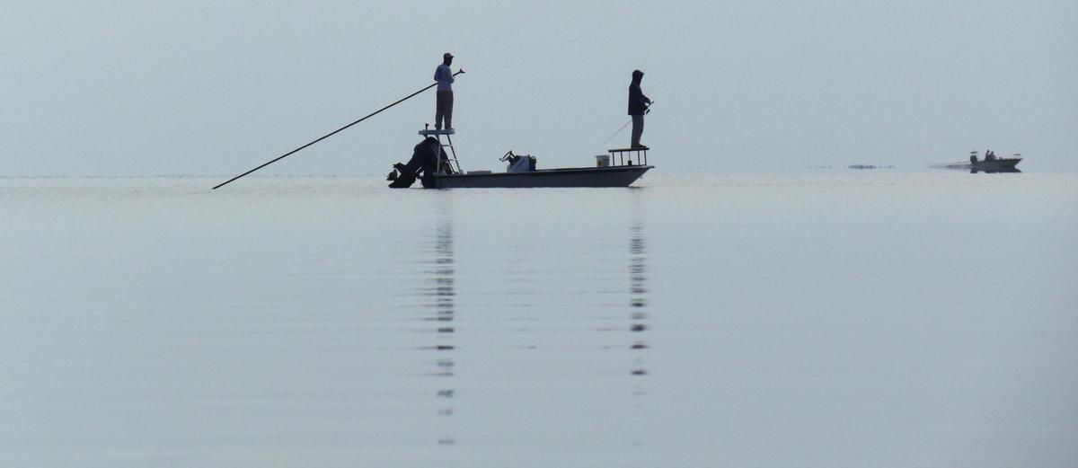 Fishermen fish off of a flats boat in southern Biscayne Bay on a calm September morning.