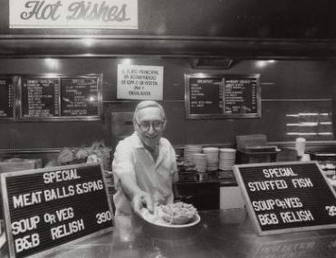 Henry Dreyfuss serves a meal to a customer at the steam table.
