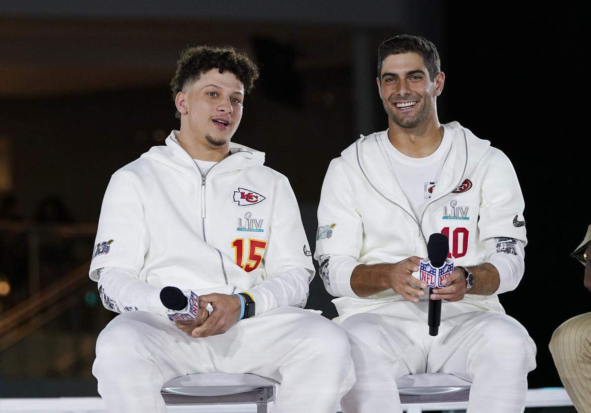 Kansas City Chiefs’ Patrick Mahomes, right, chats with San Francisco 49ers’ Jimmy Garoppolo during Opening Night for the NFL Super Bowl 54 football game Monday, Jan. 27, 2020, at Marlins Park in Miami.