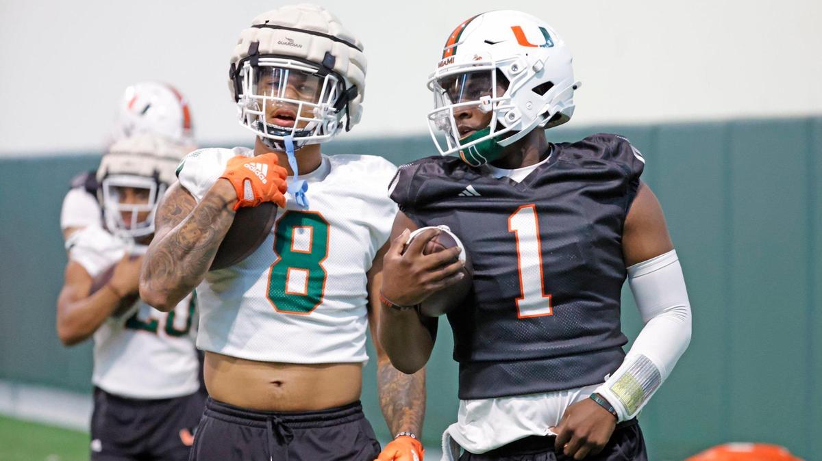 Miami Hurricanes quarterback Cam Ward (1) and tight end Elijah Arroyo (8) run between practice drills at the Carol Soffer Indoor Practice Facility in Coral Gables, Florida on Wednesday, March 6, 2024.