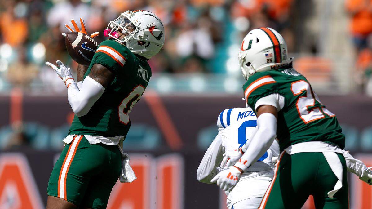 Miami Hurricanes quarterback Cam Ward (1) scrambles for yardage as Hurricanes center Zach Carpenter (50) blocks during the first half of an ACC football game against the Duke Blue Devils at Hard Rock Stadium on Saturday, Nov. 2, 2024, in Miami Gardens, Fla.