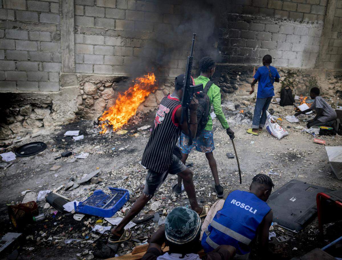 A teenage gang member walks with a rifle during a raid in Port-au-Prince on Dec. 13, 2024. The United Nations estimates that about half of the country’s gang members are children.
