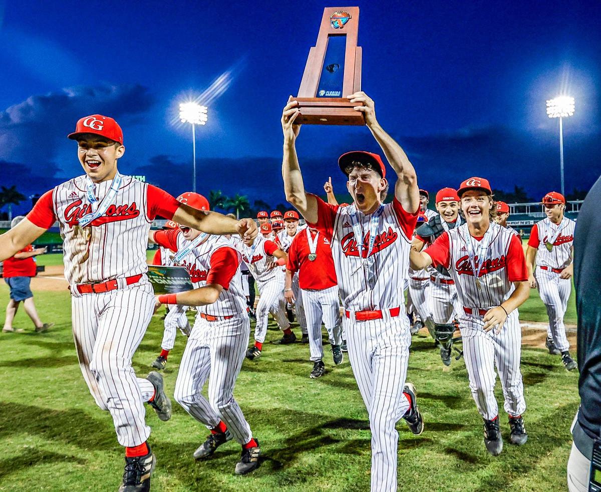 Cardinal Gibbons Chiefs Michael Kass (13) carries the FHSAA Baseball Class 4A State Championship Trophy after the team defeats the South Walton Seahawks at Hammond Stadium in Fort Myers, Florida on Wednesday, May 22, 2024.