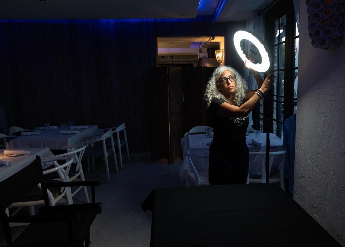 Lee sets up her ring light before laying out her makeup on a table inside NOMA Beach at Redfish before a long commercial shoot for the Herman Agency on July 11, 2023. Lee’s gigs can have a great range in length – she has been on set for five minutes for breaking news shoots and has had shoots last as long as 14 hours. Lee always keeps a kit prepared and ready to go, just in case. She has different sets of brushes for each model or actor on set. “It takes away having to get ready if you always stay ready,” Lee said.