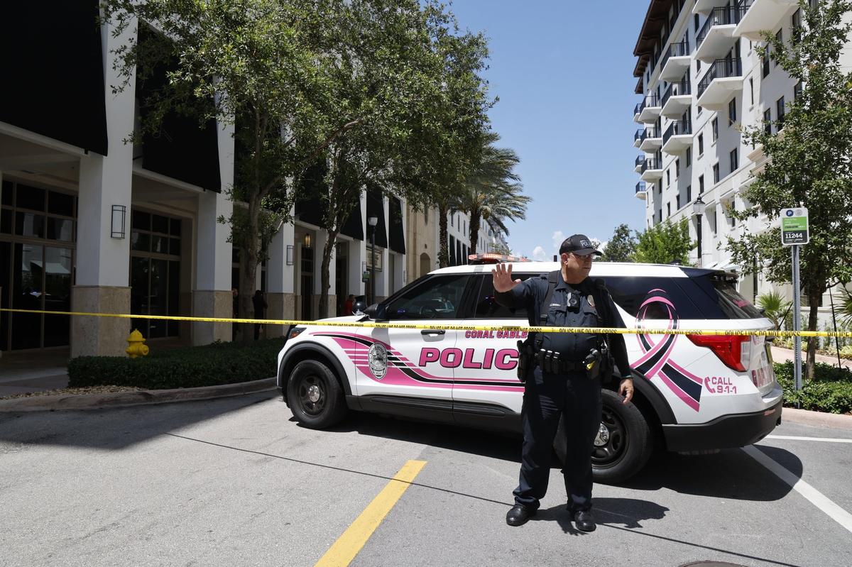 Coral Gables, Florida, June 6, 2024 - Coral Gables police officer J. Coleman directs passersby away from the scene at the Gables Ponce apartment building, 310 Granello Ave., where Miami-Dade police say three people were shot inside an apartment, two fatally, in Coral Gables, Florida, June 6, 2024. The shooting was a murder-suicide, police say.