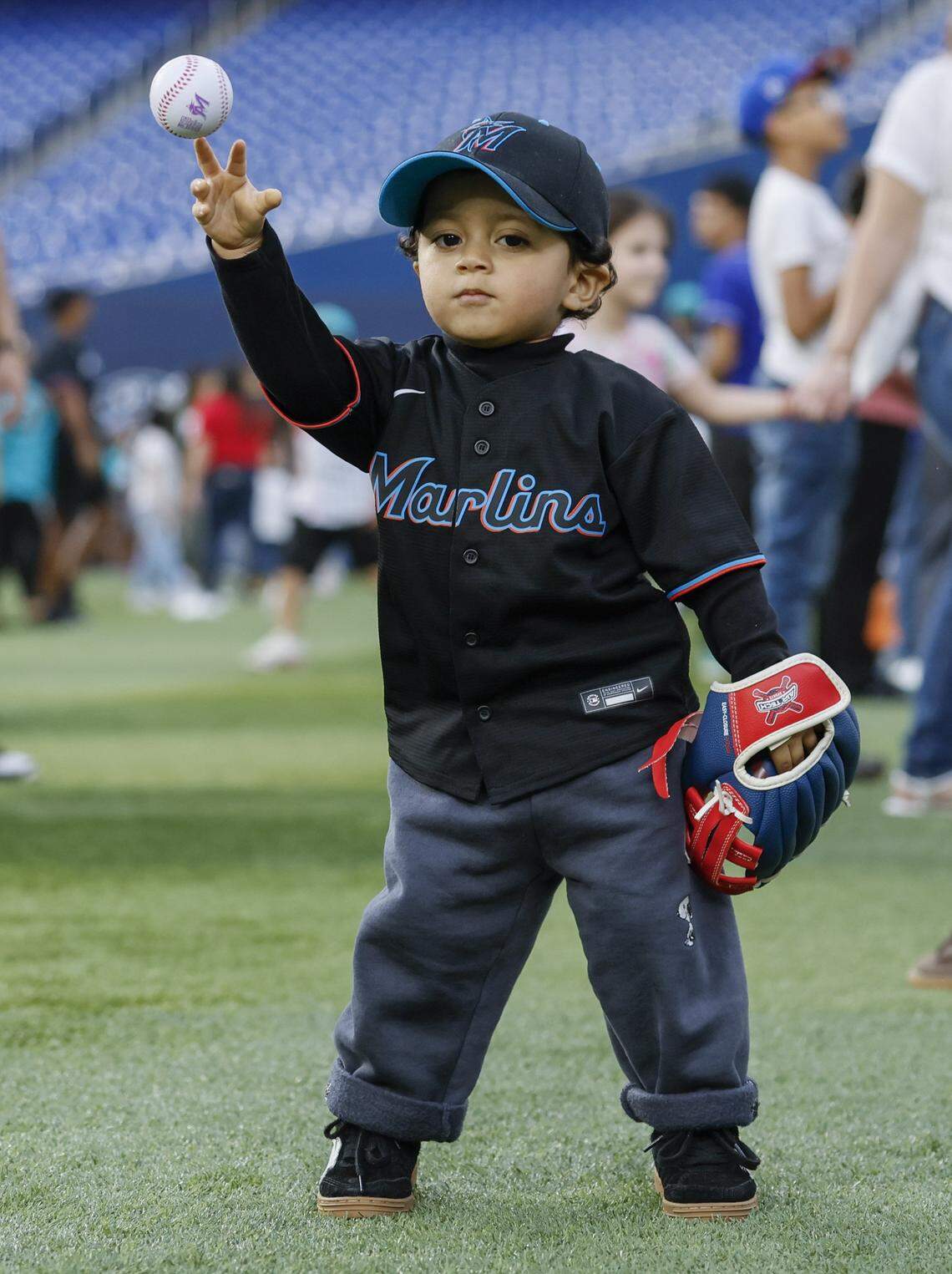 Benjamin Cabrera-Carrion, 2, throws a baseball while standing in the outfield during Marlins Fan Fest at  loanDepot park in Miami on Saturday, February 7, 2026. 