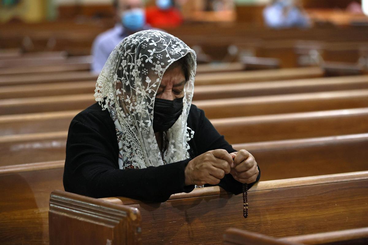 Sonia Rivas prays during Sunday Mass at St. Joseph’s Catholic Church in Miami Beach on June 27, 2021. Some of the church’s parishioners were among the missing after the condo collapse in nearby Surfside on Thursday, June 24.