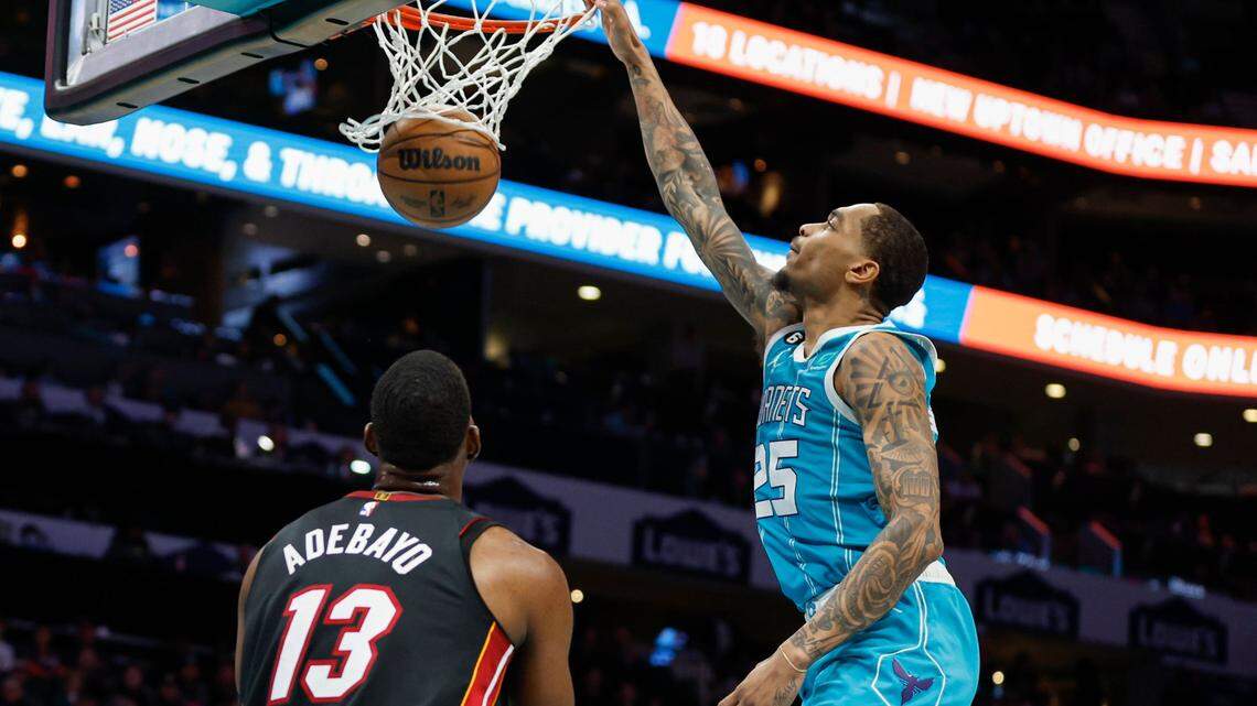Charlotte Hornets forward P.J. Washington (25) dunks as Miami Heat center Bam Adebayo (13) looks on during the first half of an NBA basketball game in Charlotte, N.C., Sunday, Jan. 29, 2023.
