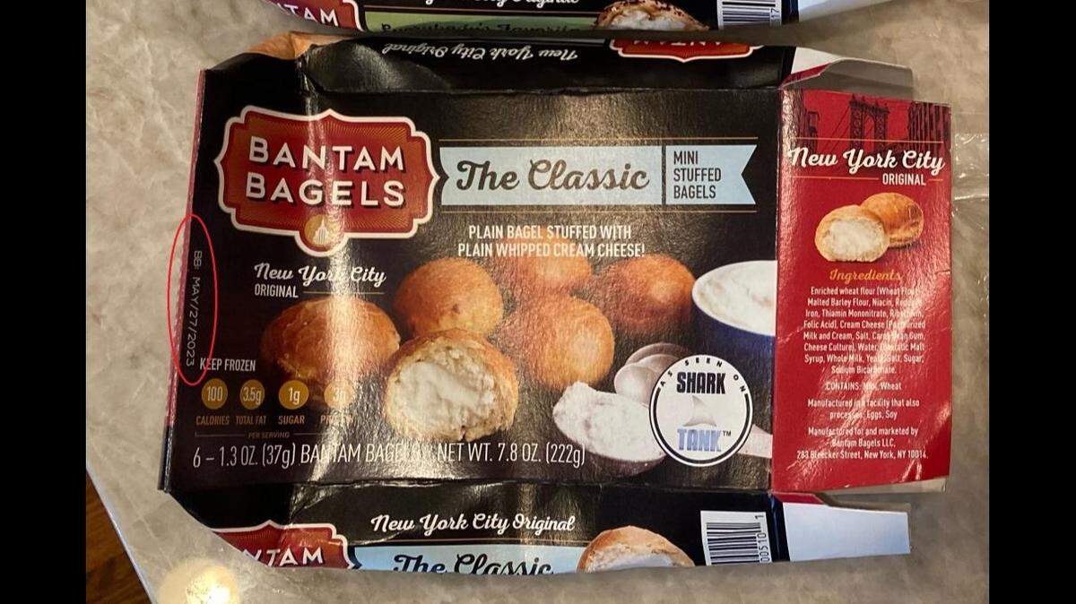 A box of recalled Bantam Bagels mini-stuffed bagels with cream cheese. The red circle shows where you can find the lot number and best by date.