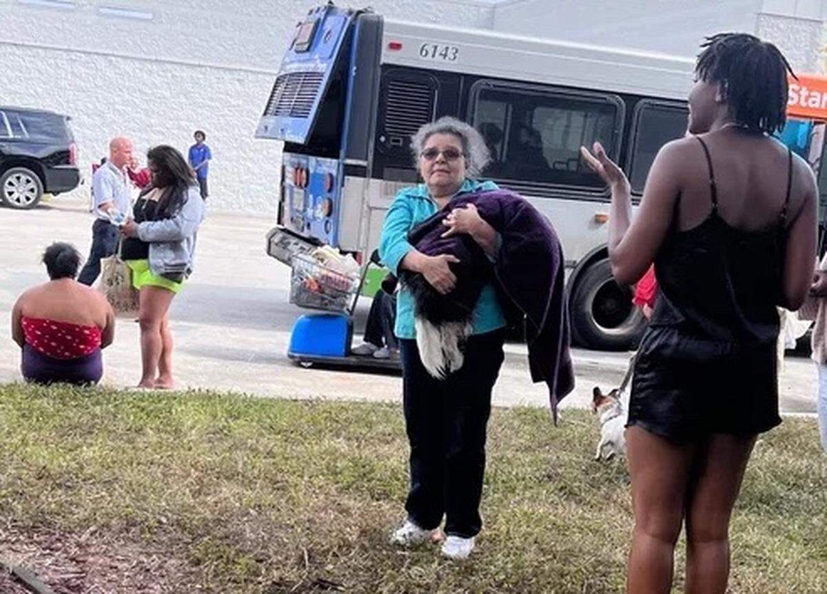 Nidia Lau, 61, holds her 18-year-old shih tzu Banti near her apartment complex on Saturday. Lau was among the 105 people displaced after a fire engulfed dozens of units at a two-story apartment building at 395 NW 177th St. in Miami Gardens.