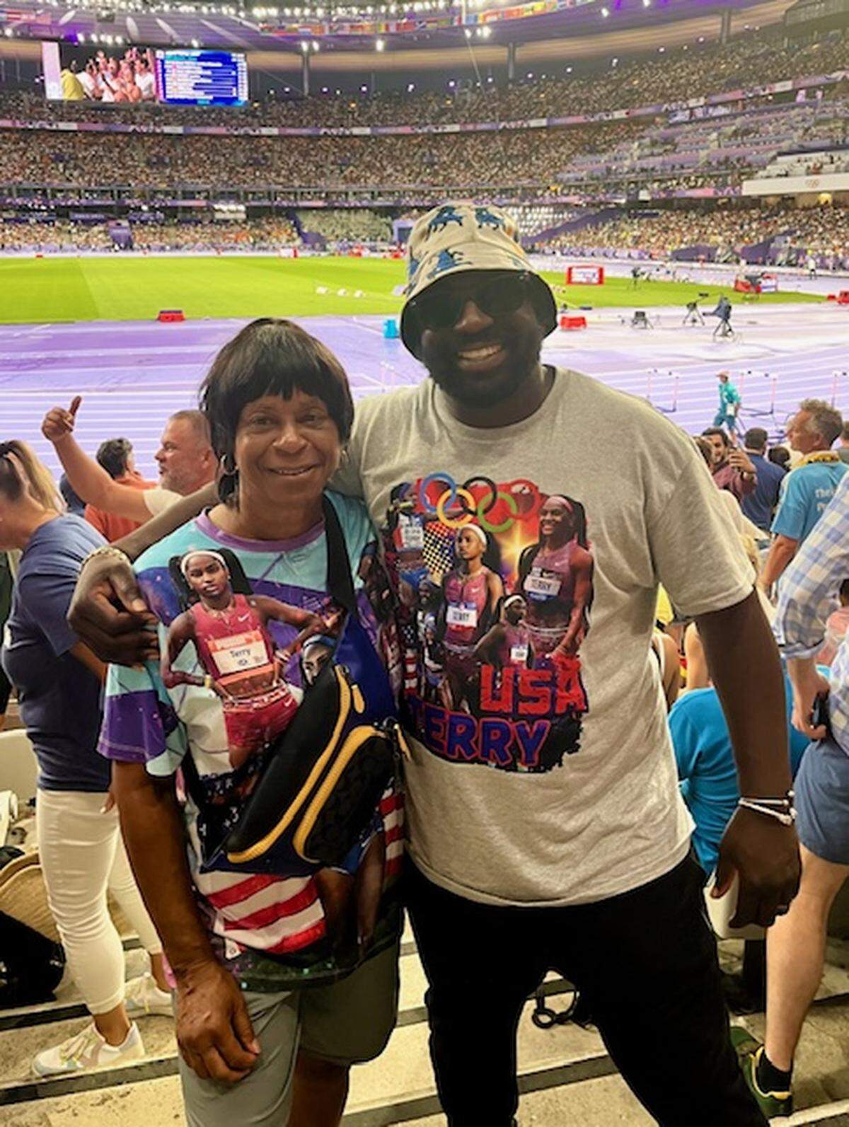 Miami Northwestern High School Coach Carmen Jackson and Antwan Terry, father of gold medalist Twanisha Terry, in Estade de France stand at Paris Olympics for track and field competition.